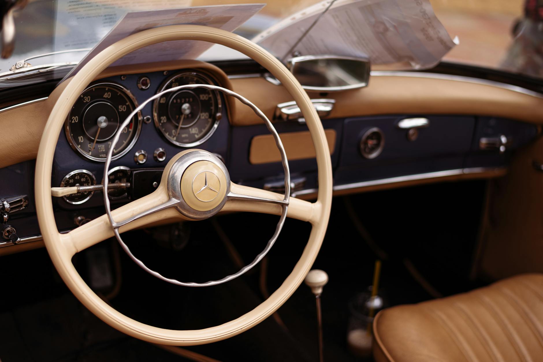 Close-up of the vintage steering wheel and dashboard in an elegant classic Mercedes-Benz car.